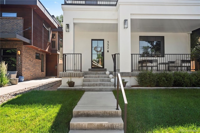 332 S Franklin St, Denver, CO 80209 - doorway to property with covered porch, stucco siding, and a yard