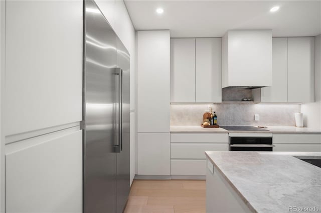 332 S Franklin St, Denver, CO 80209 - kitchen with oven, built in refrigerator, modern cabinets, light countertops, and recessed lighting