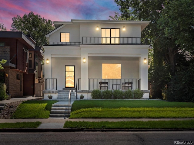 332 S Franklin St, Denver, CO 80209 - view of front of house with a balcony, stucco siding, covered porch, and a yard