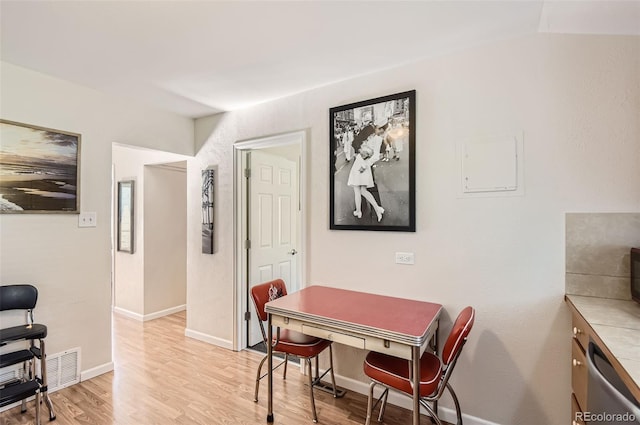 dining room featuring vaulted ceiling and light hardwood / wood-style flooring