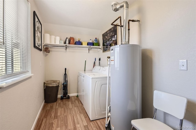 washroom with water heater, light hardwood / wood-style flooring, and separate washer and dryer