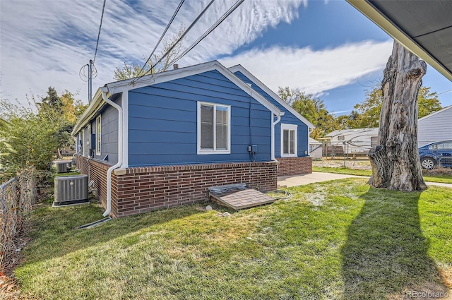 view of home's exterior with cooling unit and a lawn