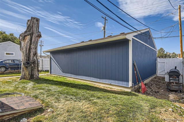 view of side of property with an outbuilding and a yard