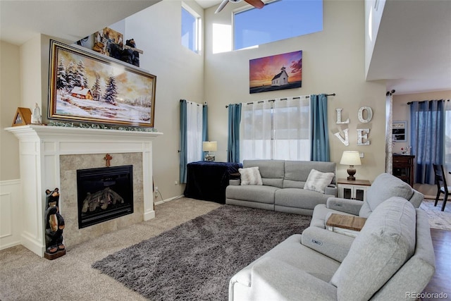 carpeted living room featuring a towering ceiling and a fireplace