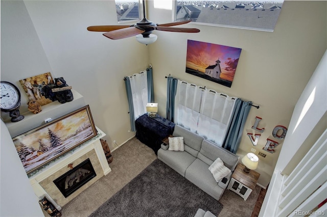 carpeted living room featuring a towering ceiling and ceiling fan