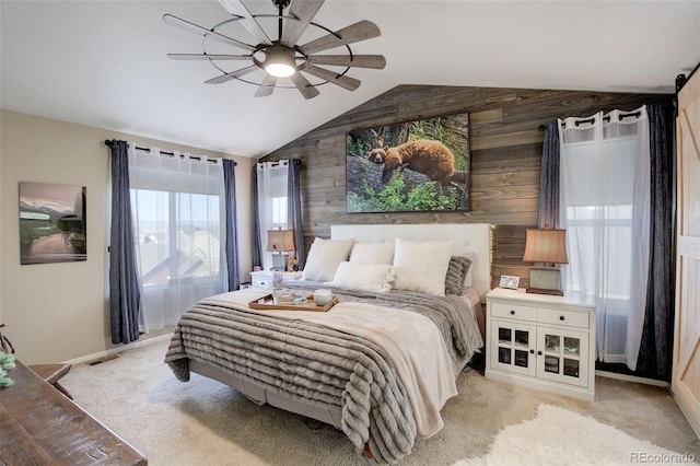 bedroom with light carpet, wooden walls, lofted ceiling, and ceiling fan