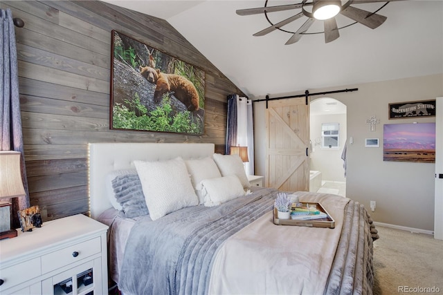 carpeted bedroom with lofted ceiling, wooden walls, a barn door, and ceiling fan