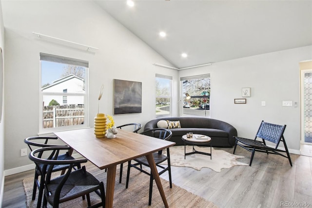 dining room featuring baseboards, recessed lighting, wood finished floors, and high vaulted ceiling