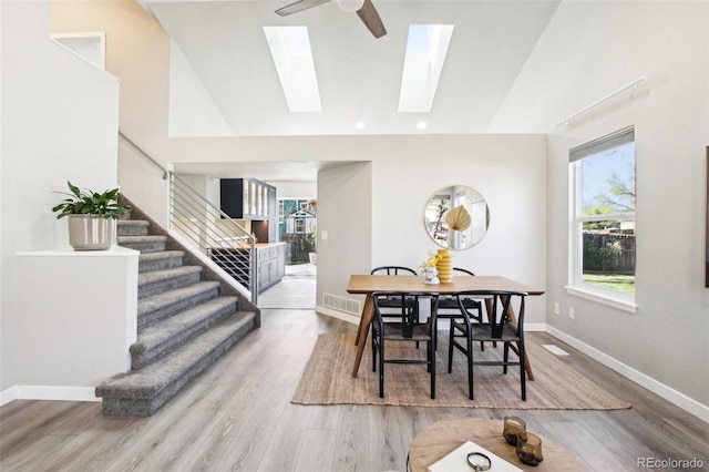 dining space featuring light wood-type flooring, stairs, and visible vents
