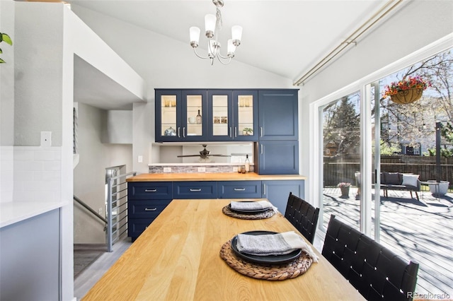 dining room featuring a notable chandelier, vaulted ceiling, and wood finished floors