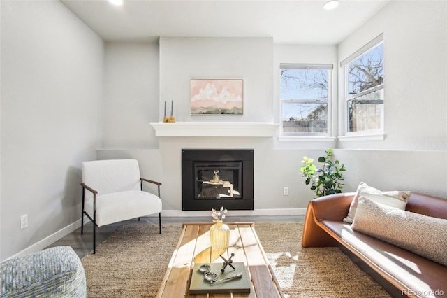 living area featuring recessed lighting, baseboards, and a glass covered fireplace