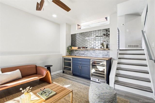 bar with bar, decorative backsplash, beverage cooler, and visible vents