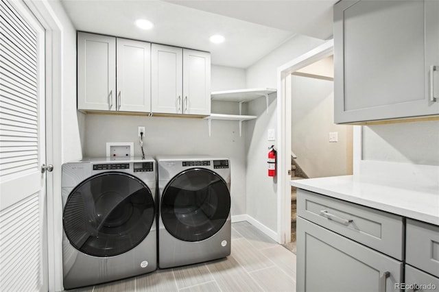 laundry room featuring baseboards, recessed lighting, cabinet space, and washer and clothes dryer