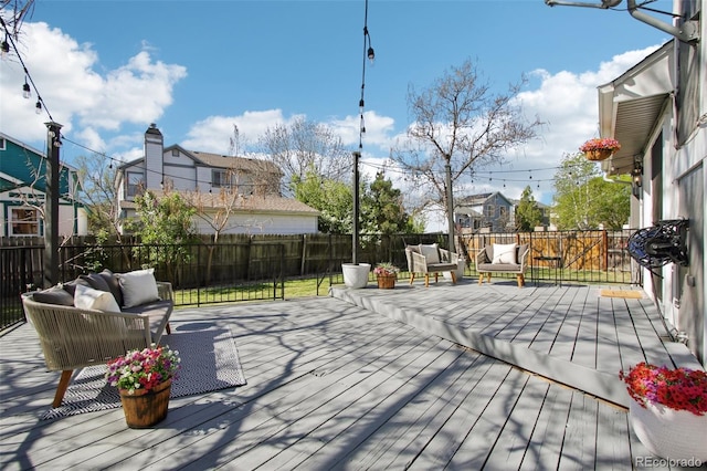 wooden deck featuring an outdoor living space, a fenced backyard, and a residential view