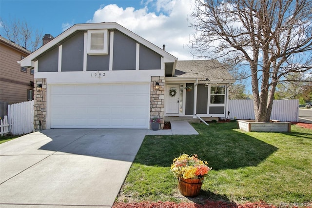 view of front of house with fence, driveway, stone siding, and a garage