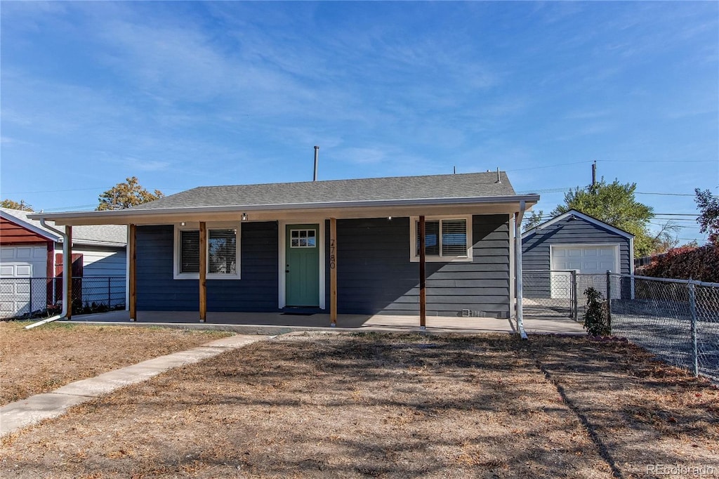 view of front of house featuring a garage, a porch, and an outbuilding