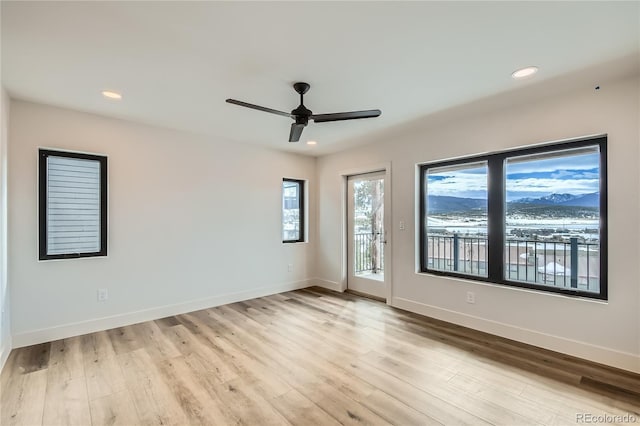 spare room featuring a ceiling fan, recessed lighting, light wood-style flooring, and baseboards