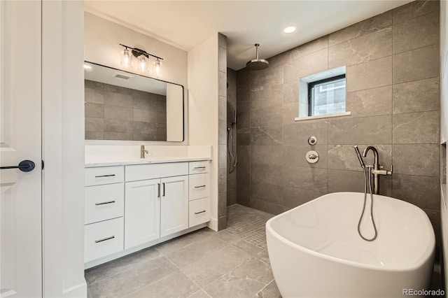 bathroom with a freestanding tub, tile walls, vanity, and walk in shower