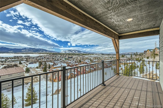 snow covered back of property with a residential view and a mountain view