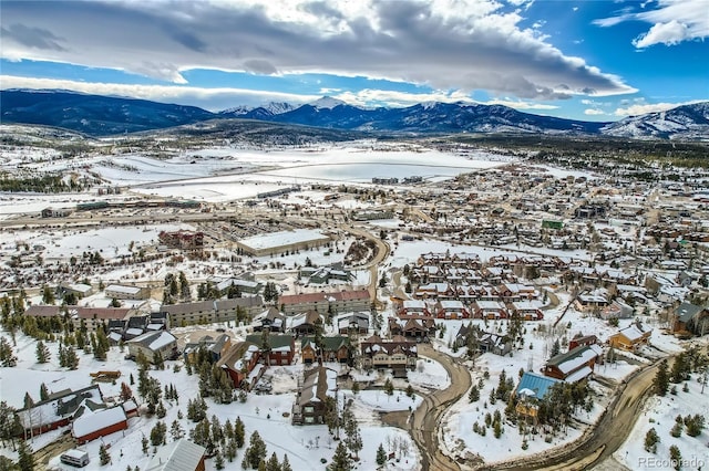 snowy aerial view featuring a residential view and a mountain view