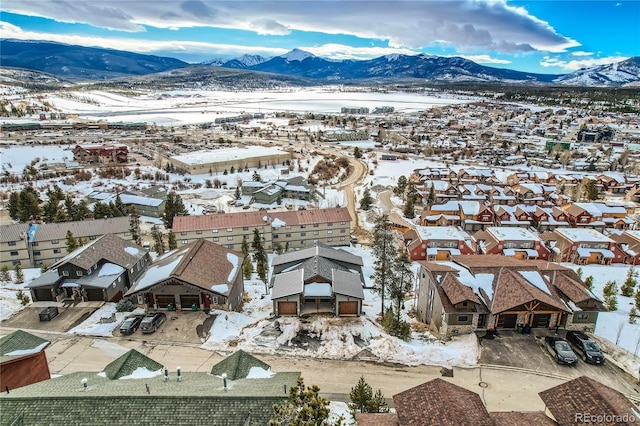 snowy aerial view with a mountain view and a residential view