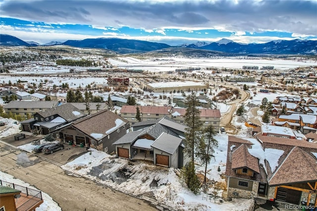 snowy aerial view with a residential view and a mountain view