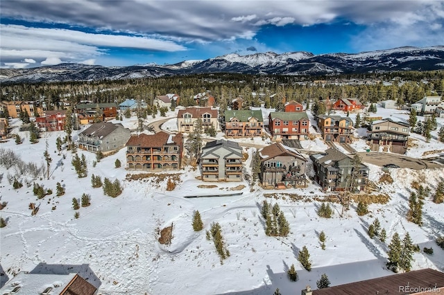 snowy aerial view featuring a residential view and a mountain view