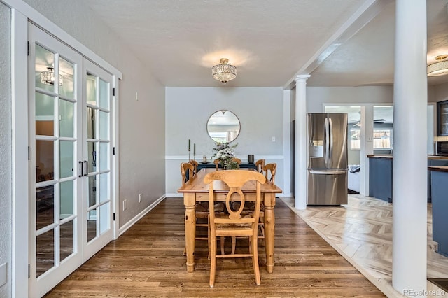 dining space featuring french doors, ornate columns, and parquet floors
