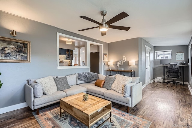 living room featuring a ceiling fan, baseboards, and wood finished floors