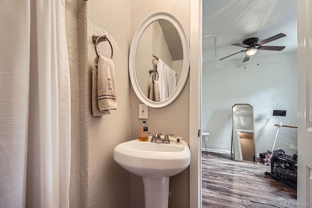 bathroom featuring a sink, a textured wall, a ceiling fan, and wood finished floors