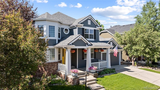 16376 Stonefeld Pl, Parker, CO 80134 - view of front of home featuring covered porch, roof with shingles, driveway, a front lawn, and a garage