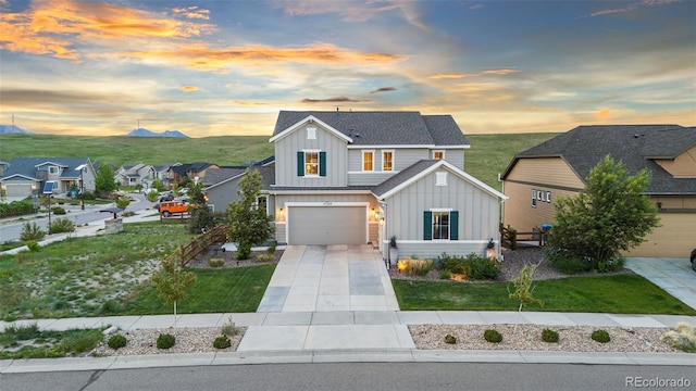 17335 W 94th Ave, Arvada, CO 80007 - view of front of home with board and batten siding, concrete driveway, an attached garage, a residential view, and a mountain view