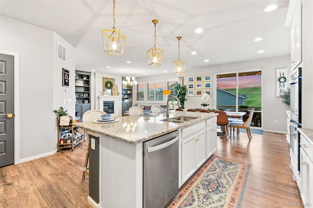 17335 W 94th Ave, Arvada, CO 80007 - kitchen featuring stainless steel appliances, a sink, recessed lighting, white cabinets, and a center island with sink