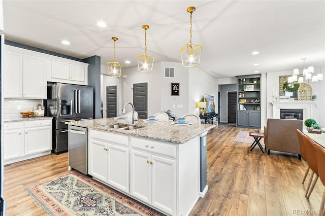 17335 W 94th Ave, Arvada, CO 80007 - kitchen with a sink, appliances with stainless steel finishes, recessed lighting, open floor plan, and light wood-style floors