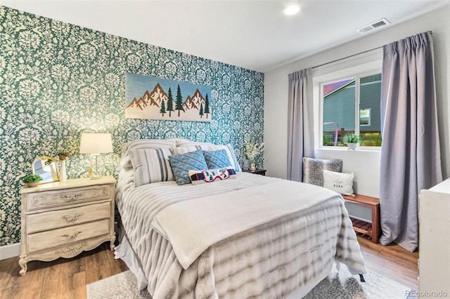 17335 W 94th Ave, Arvada, CO 80007 - bedroom with wallpapered walls, wood finished floors, baseboards, and an accent wall