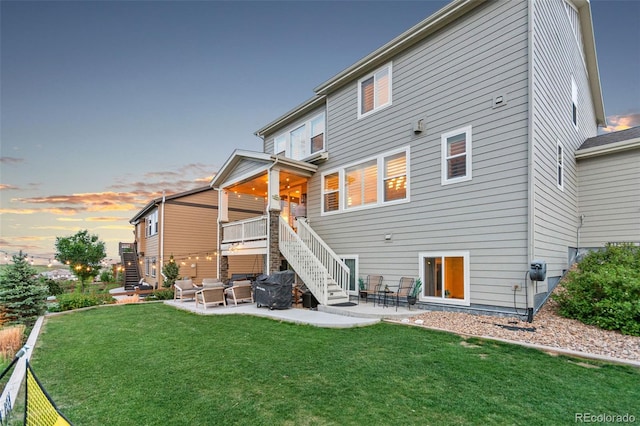 17335 W 94th Ave, Arvada, CO 80007 - back of house at dusk featuring stairs, a yard, and a patio