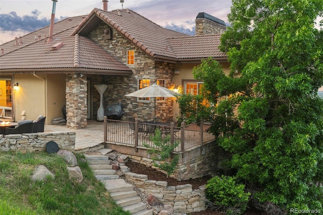 back house at dusk with a patio