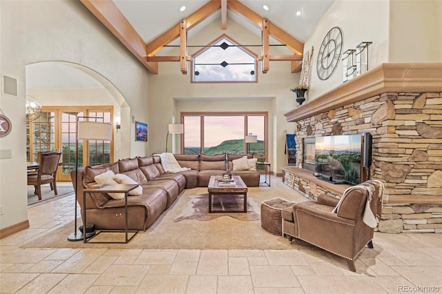 living room with beamed ceiling and high vaulted ceiling