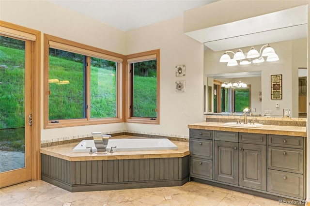 bathroom with vanity, a notable chandelier, tile patterned floors, and a bathing tub