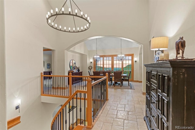 hallway featuring a high ceiling and a chandelier