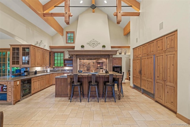 kitchen with a kitchen island, a breakfast bar, high vaulted ceiling, beamed ceiling, and wine cooler