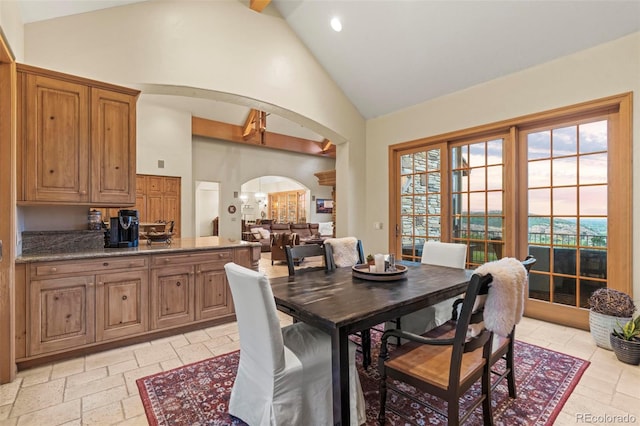 dining space with high vaulted ceiling