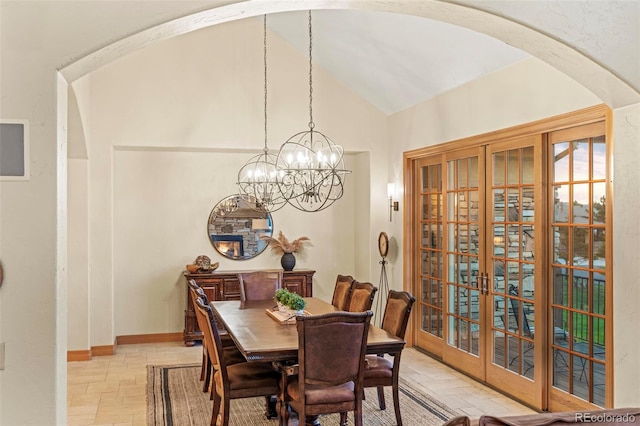 dining room with french doors, an inviting chandelier, and vaulted ceiling