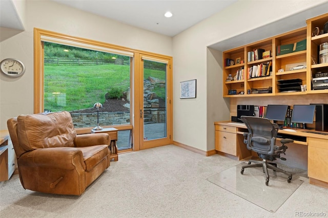 office area with built in desk and light carpet