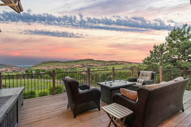 deck at dusk with a mountain view and an outdoor fire pit