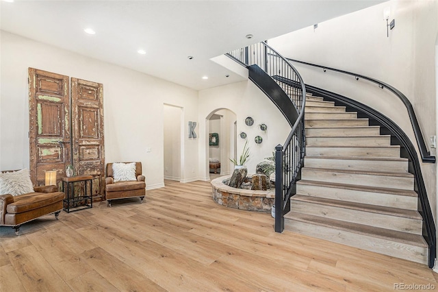 12963 Silver Elk Ln, Littleton, CO 80127 - stairway with arched walkways, wood finished floors, recessed lighting, baseboards, and a high ceiling