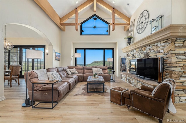 12963 Silver Elk Ln, Littleton, CO 80127 - living room with high vaulted ceiling, a chandelier, beam ceiling, arched walkways, and light wood finished floors