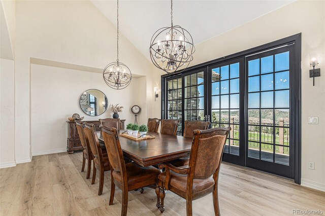 12963 Silver Elk Ln, Littleton, CO 80127 - dining space featuring a chandelier, light wood-style flooring, baseboards, and a towering ceiling