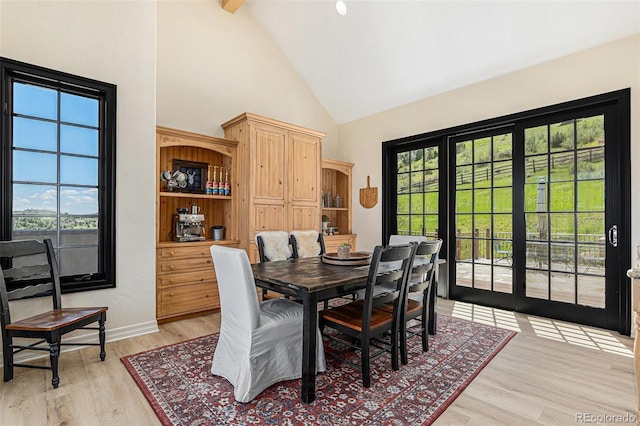 12963 Silver Elk Ln, Littleton, CO 80127 - dining room featuring high vaulted ceiling, light wood-style floors, baseboards, and beam ceiling