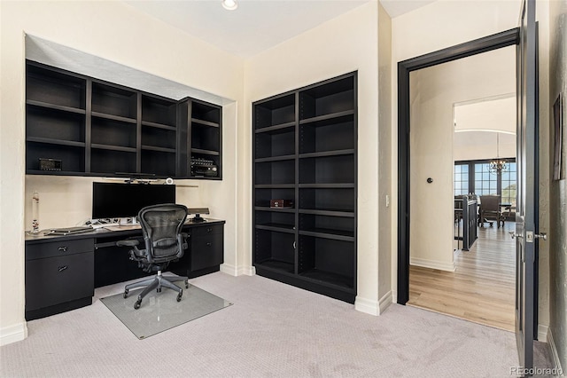 12963 Silver Elk Ln, Littleton, CO 80127 - office with light carpet, built in shelves, baseboards, and built in study area